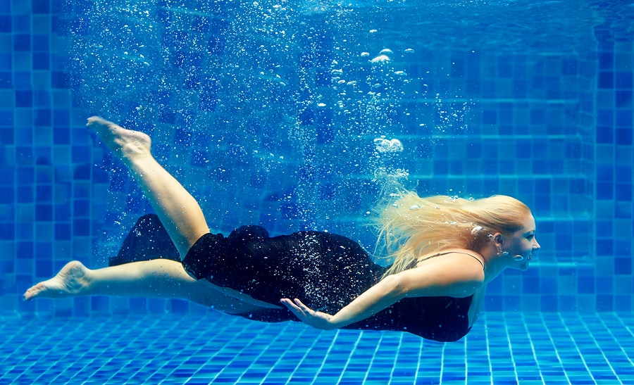 beautiful plus size woman diving in pool