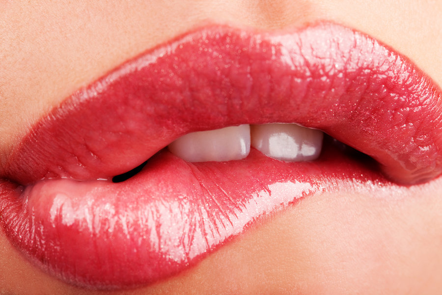 Closeup of woman chewing lips